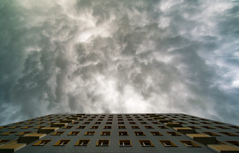 Facade a building and a stormy sky. Severe weather planning concept